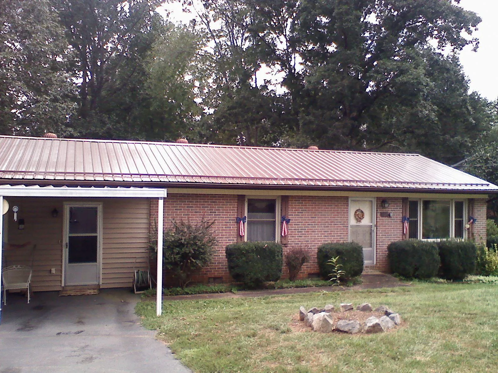 Bronze metal roof and carport on a brick ranch home — Roof Repair work by our crew in Cicero
